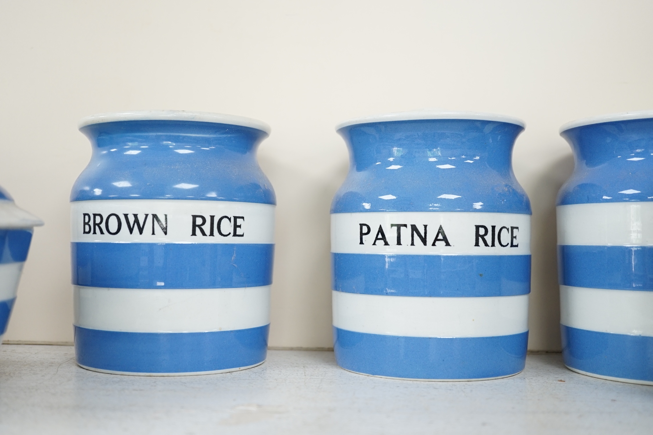 T.G.Green Cornish Kitchenware, fifteen lidded storage jars, to include Moist Sugar, Spaghetti, Semolina, Patna Rice, Brown Rice, Butter and Lard, largest 14cm high, Black Shield marks. Condition - poor, fair and good